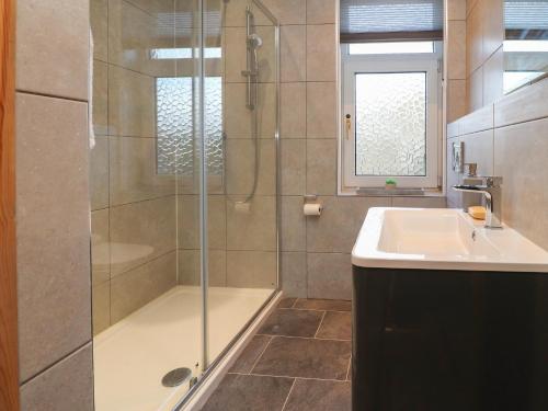 a bathroom with a shower and a sink at 10 Haw Grove in Skipton