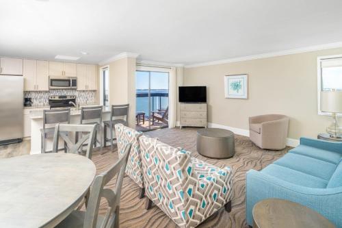 a living room with a table and chairs and a kitchen at Bask Hotel at Big Rock Landing in Morehead City