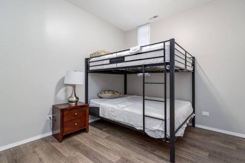 ein Schlafzimmer mit einem Etagenbett und einem Nachttisch in der Unterkunft Suite 1 on Southport 4 Queen Beds in Chicago