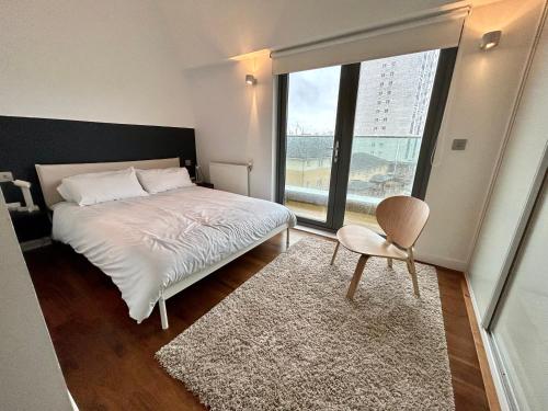 Stay in Style: Modern 2-Bed In Trendy London Area في لندن: غرفة نوم بسرير ونافذة كبيرة