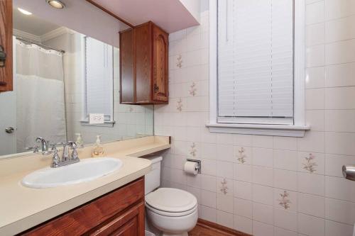 a bathroom with a sink and a toilet and a window at MTM Fully Furnished Rental in Old Town - 2 Beds in Chicago