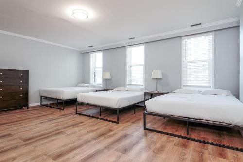 Habitación con 2 camas, suelo de madera y ventanas. en Beautiful Remodeled Penthouse Unit in Old Town en Chicago