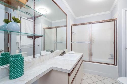 uma casa de banho com um lavatório e um espelho grande em Beautiful Remodeled Penthouse Unit in Old Town em Chicago