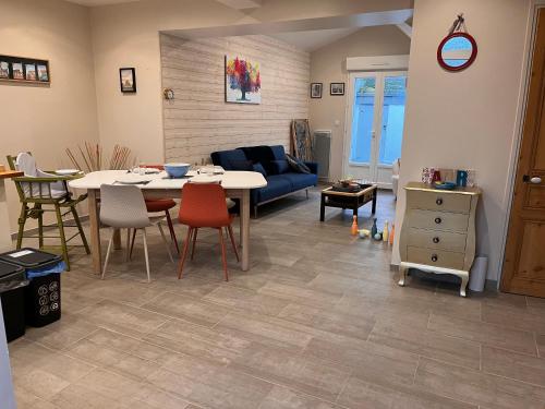 un salon avec une table et un canapé bleu dans l'établissement La Serjane à 300 m de la mer à Cayeux sur mer, à Cayeux-sur-Mer