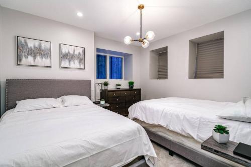 2 Betten in einem Schlafzimmer mit weißen Wänden und Fenstern in der Unterkunft Immaculate Brand New Condo Downtown in Chicago