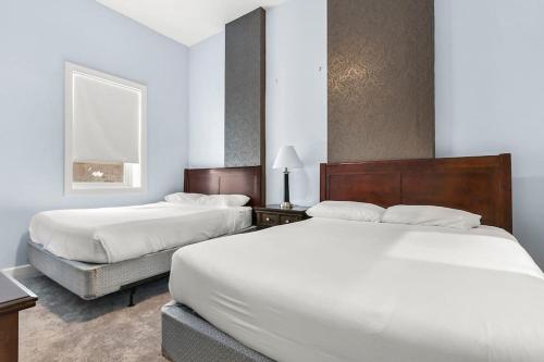 duas camas num quarto de hotel com lençóis brancos em Lovely 2-Bedroom Unit in Springfriend em Springfield