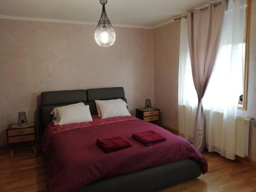 - une chambre avec un lit doté de draps rouges et une fenêtre dans l'établissement La dolce vita (150m2) : maison 4 chambres, à Anzin