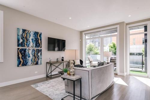 a white living room with a couch and a tv at Stunning Duplex Condo #1 - Downtown River North in Chicago