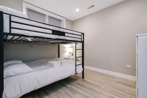 a bedroom with a bunk bed with white sheets at Stunning Duplex Condo #1 - Downtown River North in Chicago