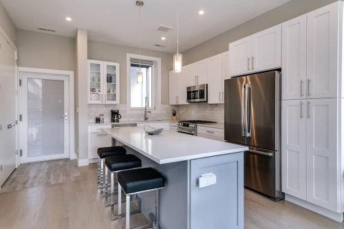 a kitchen with white cabinets and a stainless steel refrigerator at Stunning Condo #2 - Downtown River North in Chicago