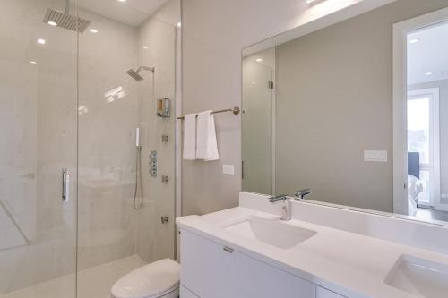 een witte badkamer met een wastafel en een douche bij Breathtaking Downtown Penthouse A - Sleeps 11 in Chicago