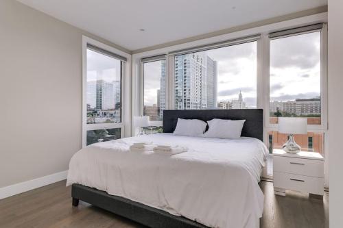 a bedroom with a large white bed with windows at New Construction Building in River North in Chicago