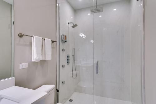 a white bathroom with a shower and a sink at New Construction Building in River North in Chicago