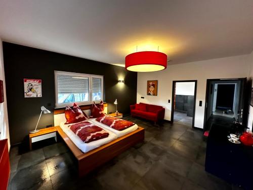ein Schlafzimmer mit einem großen Bett und einer roten Couch in der Unterkunft casa ECH Ferienhaus Oberelsbach in Oberelsbach