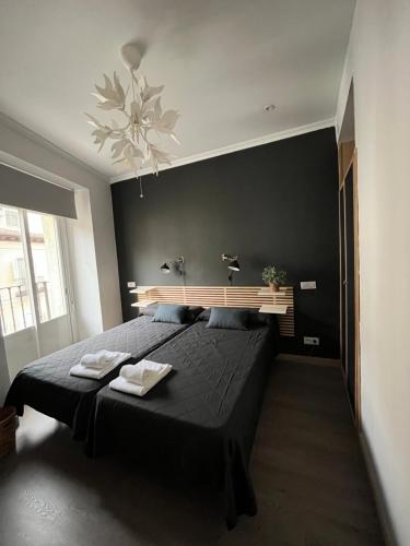 a bedroom with a large bed with black walls at Hostal Inter Plaza Mayor in Madrid