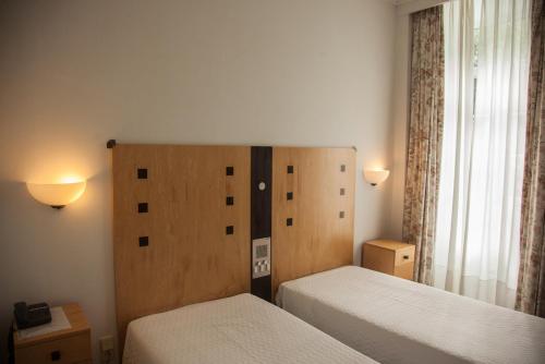 a small bedroom with two beds and a window at Hotel Das Termas in Geres