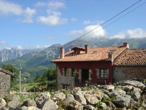 une maison sur une colline avec des rochers devant elle dans l'établissement La Portiella del Llosu, à Pandiello