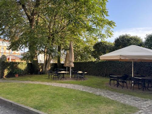 a group of tables and umbrellas in a yard at Hotel Canteklaar in De Haan