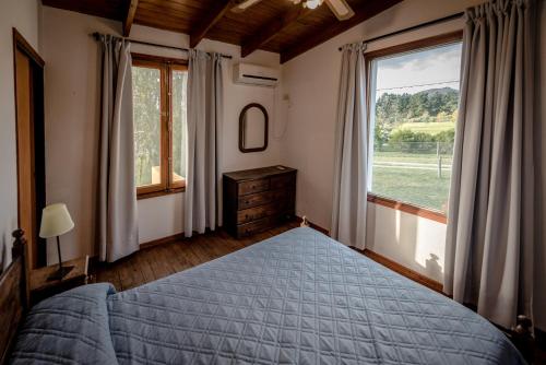 a bedroom with a bed and a large window at la candelaria in Tandil