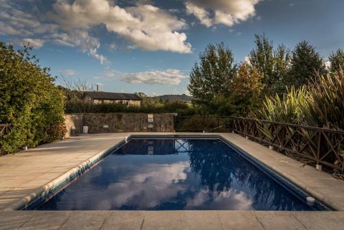 a swimming pool in a backyard with a fence at la candelaria in Tandil