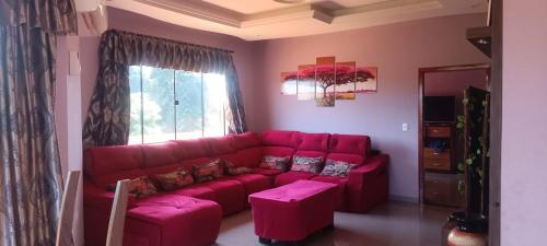 a living room with a red couch and a window at Ñande renda in Ciudad del Este