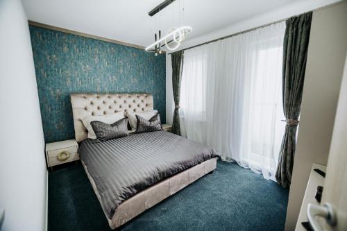 a bedroom with a bed and a blue wall at Luxury Penthouse Belvedere in Sibiu