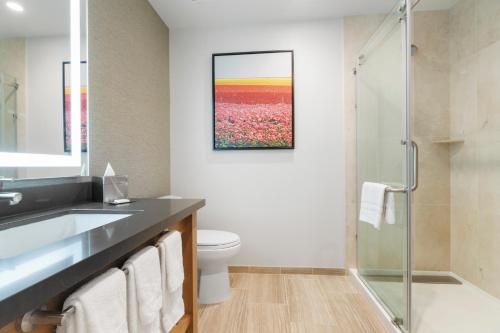 a bathroom with a toilet and a sink and a shower at Pala Mesa Resort in Fallbrook