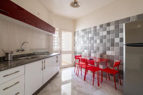 une cuisine avec des chaises rouges et une table. dans l'établissement Appt charmant, cœur d'Agdal., à Rabat