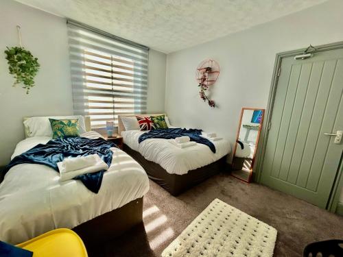 a bedroom with two beds and a window at 6 Bedroom House -Sleeps 12- Big Savings on Long Stays!! in Ipswich
