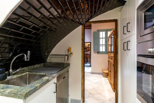 uma cozinha com um lavatório e uma parede de tijolos em Casa Guadalupe em Sevilha