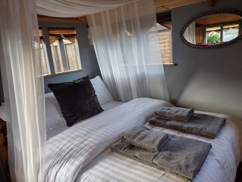 een slaapkamer met een bed met kussens erop bij Forest View Cabin in Ballaghaderreen