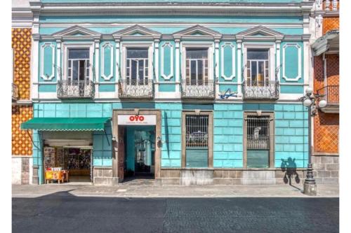 a blue and white building with a store at OYO Hotel Casona Poblana in Puebla