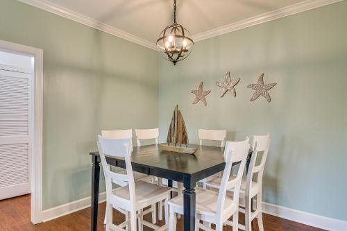 a dining room with a black table and white chairs at Foley Condo with Pool Access 10 Mi to Gulf Shores! in Foley