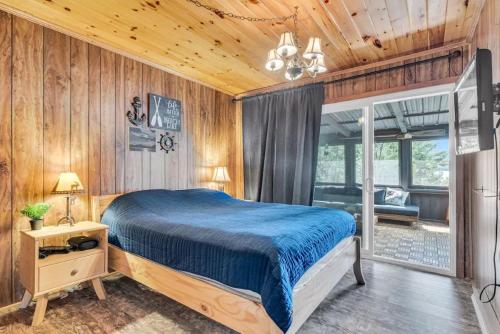 sypialnia z łóżkiem w pokoju z drewnianymi ścianami w obiekcie Entire cottage in Algonquin Highlands Canada w mieście Algonquin Highlands