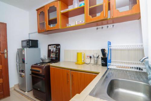 a kitchen with a sink and a refrigerator at FOREVER 3 RESIDENCE in Naivasha