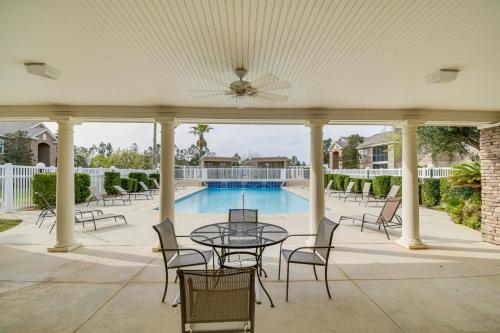 a patio with a table and chairs and a pool at Foley Condo with Pool Access 10 Mi to Gulf Shores! in Foley