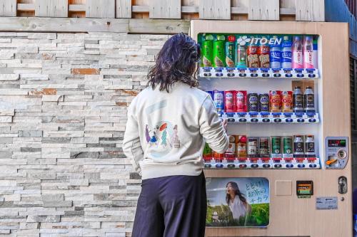 a person standing in front of a soda machine at Hotel Imagine Kyoto in Kyoto