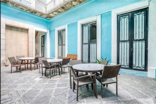 a patio with tables and chairs and windows at OYO Hotel Casona Poblana in Puebla