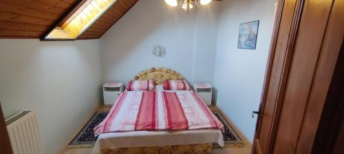 a bedroom with a bed with a red comforter at Dávid Apartmanház in Zalakaros