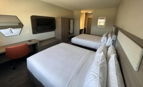 Habitación de hotel con 2 camas y escritorio en Holiday Inn Express - Wichita North - Park City, an IHG Hotel en Park City
