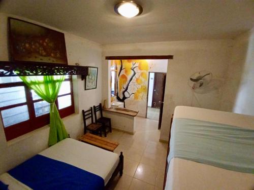 a bedroom with a bed and a room with a window at Hostal Las Mariposas Minca in Minca