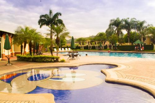 een zwembad in een resort met palmbomen bij Suite Ejecutiva 3dorms 1-8personas seguridad24h piscina in Guayaquil