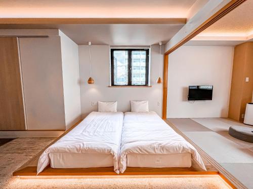 a large bed in a room with a tv at Hotel Imagine Kyoto in Kyoto