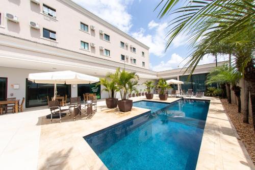 a swimming pool in front of a building at Class Hotel Pouso Alegre in Pouso Alegre