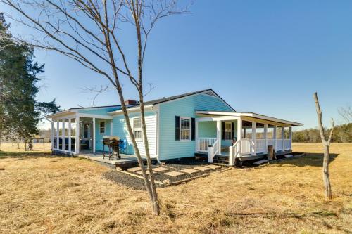 a blue tiny house with a porch at VA Wine and Horse Country Cottage, Near UVA in Ruckersville