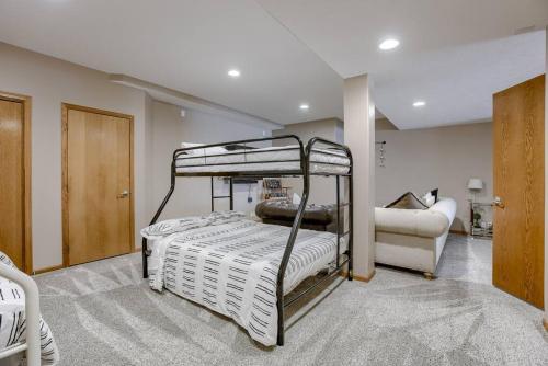a bedroom with two bunk beds and a couch at Spacious Pool House with tons of amenities! in Omaha