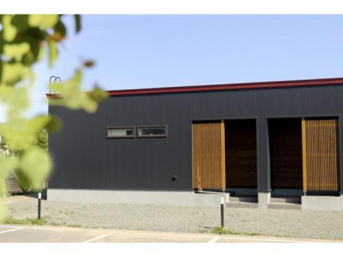 a black building with two windows in a parking lot at Phottage inn Biei - Vacation STAY 20945v in Biei