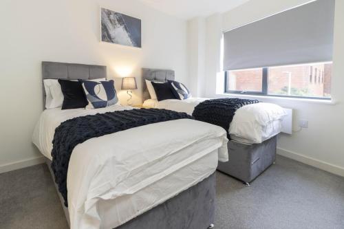 a bedroom with two beds and a window at OPP Exeter LH11 - Behind the Cathedral with free parking! BIG SAVINGS booking 7 nights or more! in Exeter