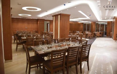 a dining room with a long table and chairs at Coral Hotel Karbala in Karbalāʼ