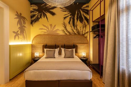 a bedroom with a large bed and a palm mural at MEDLEY in Athens